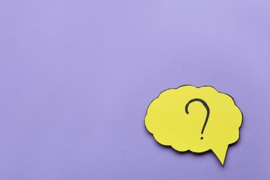 Photo of Paper speech bubble with question mark on violet background, top view. Space for text
