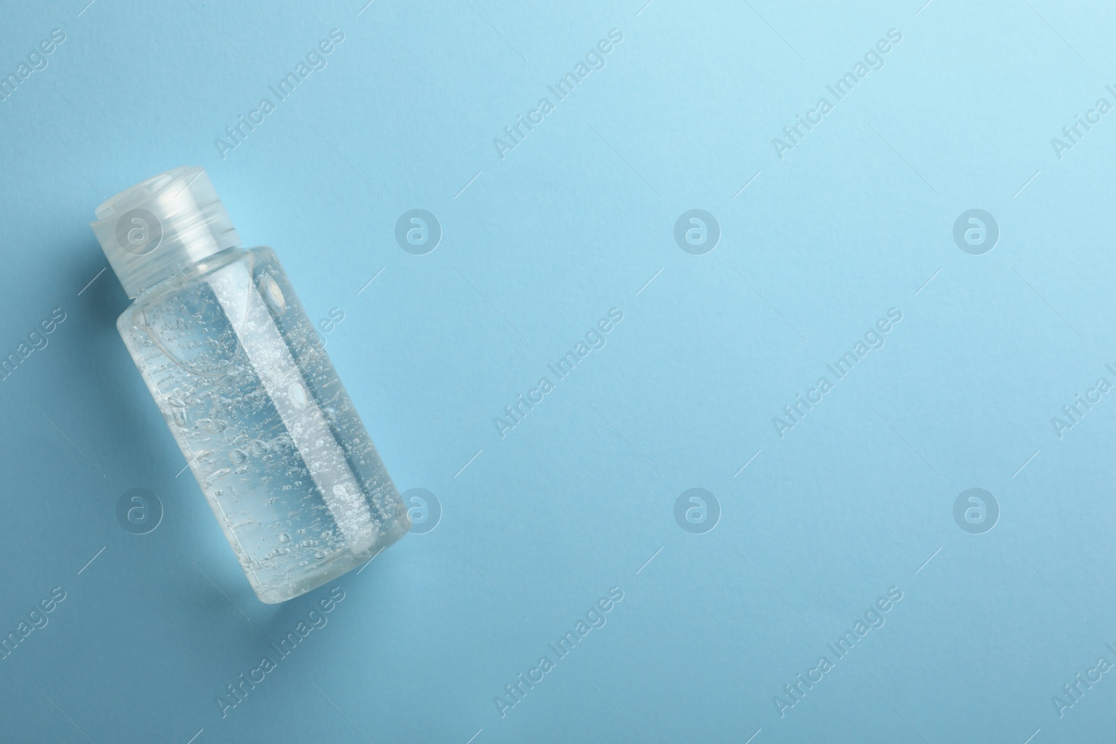 Photo of Bottle of cosmetic gel on light blue background, top view. Space for text