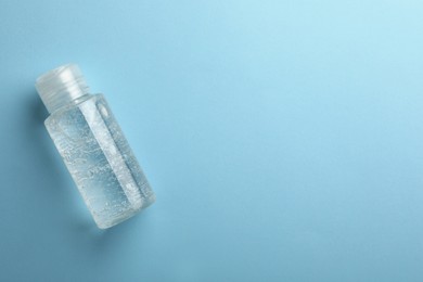 Photo of Bottle of cosmetic gel on light blue background, top view. Space for text