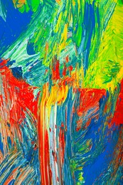 Closeup view of artist's palette with mixed bright paints as background