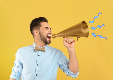 Image of Young man with megaphone on yellow background