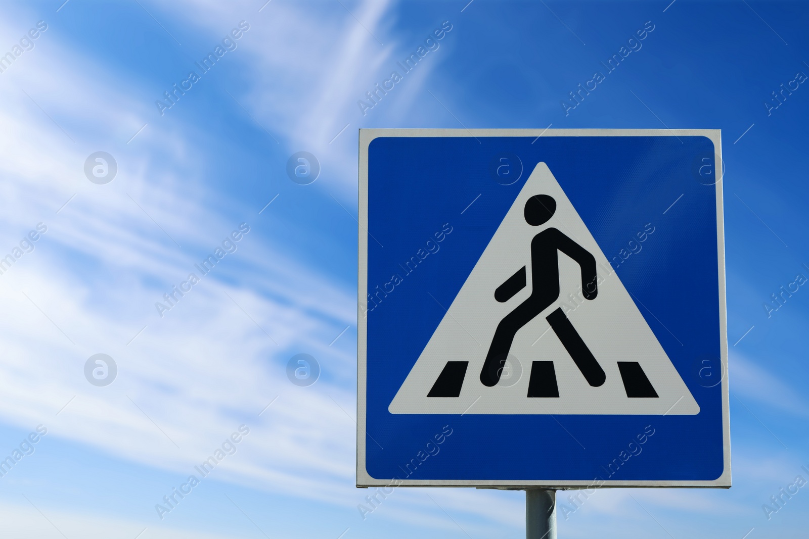 Photo of Post with Pedestrian Crossing traffic sign in city on sunny day