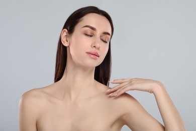 Portrait of beautiful young woman on light grey background