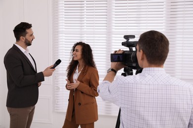 Photo of Professional journalist interviewing young African American woman indoors