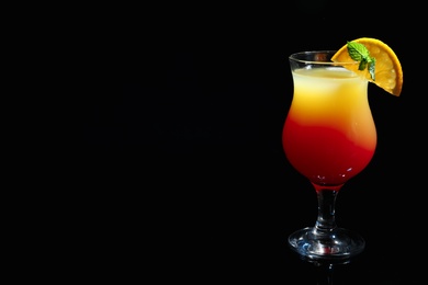 Photo of Glass of delicious cocktail Sex on the Beach decorated with orange and mint against black background. Space for text