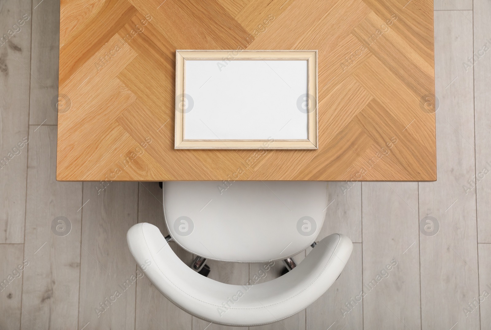 Photo of Empty photo frame on wooden table near chair indoors, top view