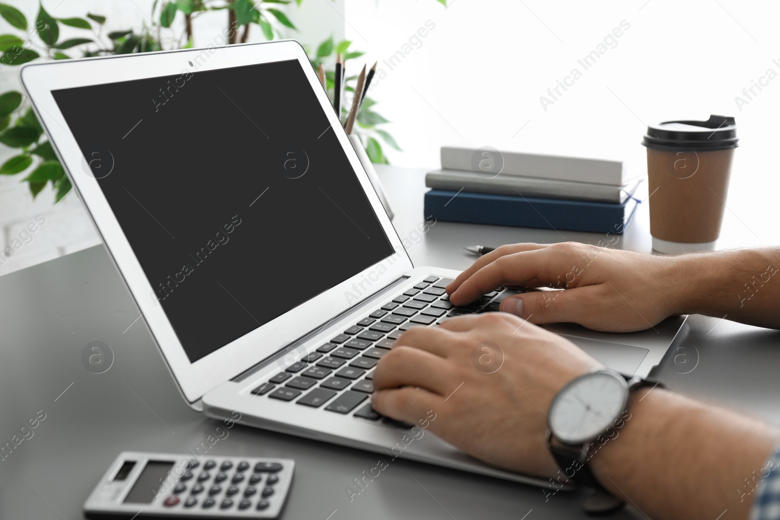 Photo of Man working with laptop at table, closeup. Space for design