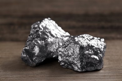 Photo of Two silver nuggets on wooden table, closeup