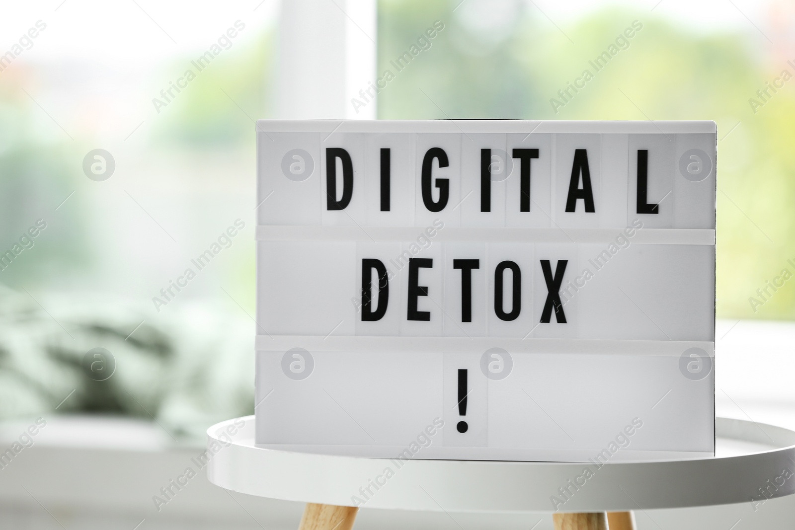 Photo of Lightbox with phrase DIGITAL DETOX on white table indoors