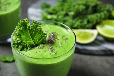 Tasty kale smoothie with chia seeds on grey table, closeup