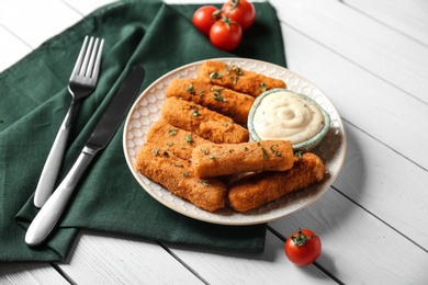 Plate of cheese sticks and sauce served on table