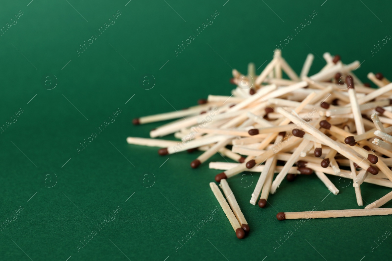 Photo of Heap of matches on color background, space for text