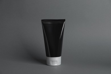 Photo of Tube of men's facial cream on grey background. Mockup for design