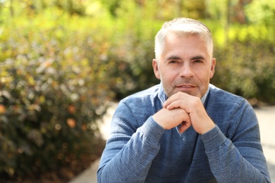 Photo of Handsome mature man in park. Space for text