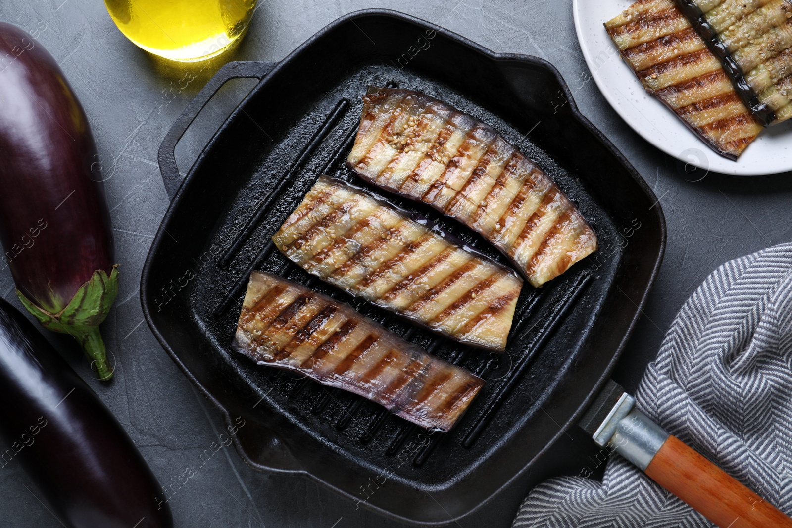 Photo of Delicious grilled eggplant slices in pan on grey table, flat lay