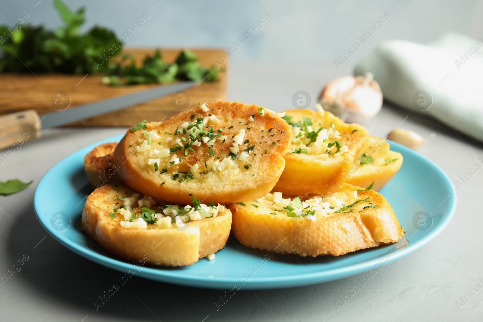 Photo of Plate with delicious homemade garlic bread on table