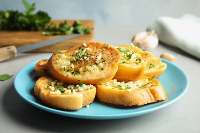 Plate with delicious homemade garlic bread on table