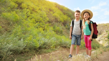 Image of Cute little children with backpacks outdoors on sunny day