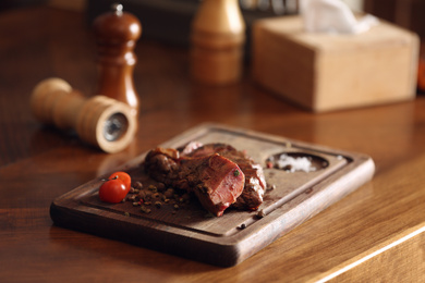 Tasty roasted meat served on wooden table. Cooking food