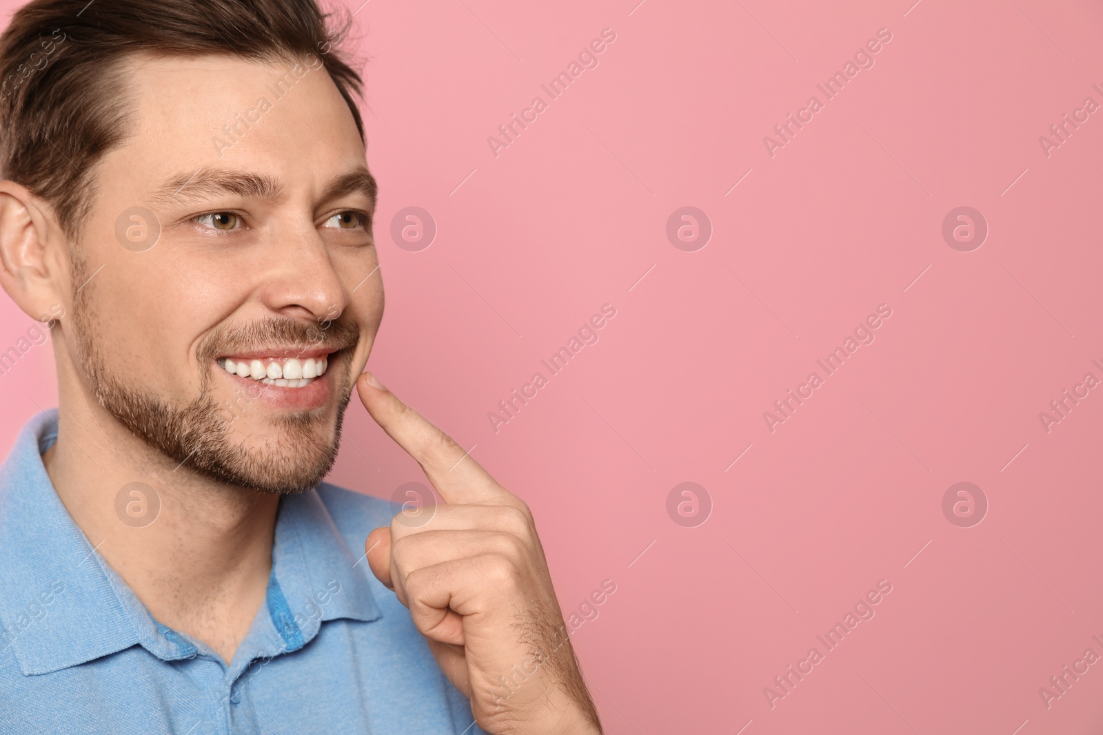 Photo of Smiling man with perfect teeth on color background. Space for text