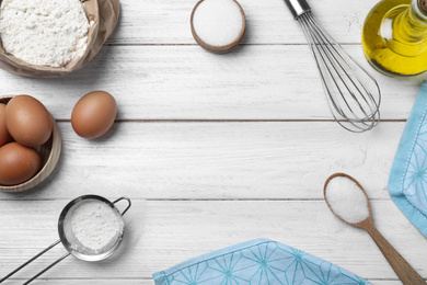 Flat lay composition with ingredients on white wooden table, space for text. Cooking thin pancakes