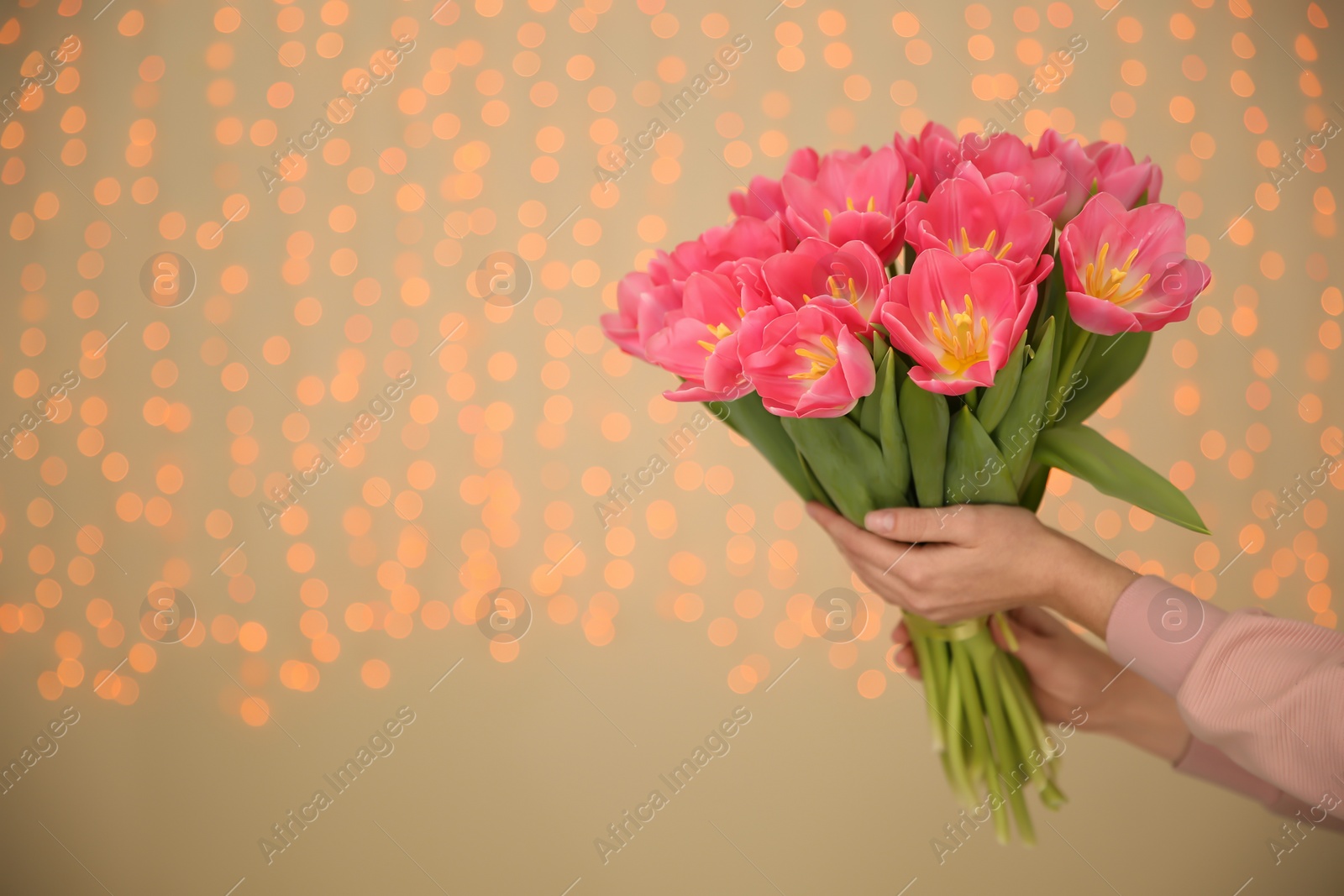 Photo of Girl holding spring tulips on blurred background, closeup with space for text. International Women's Day