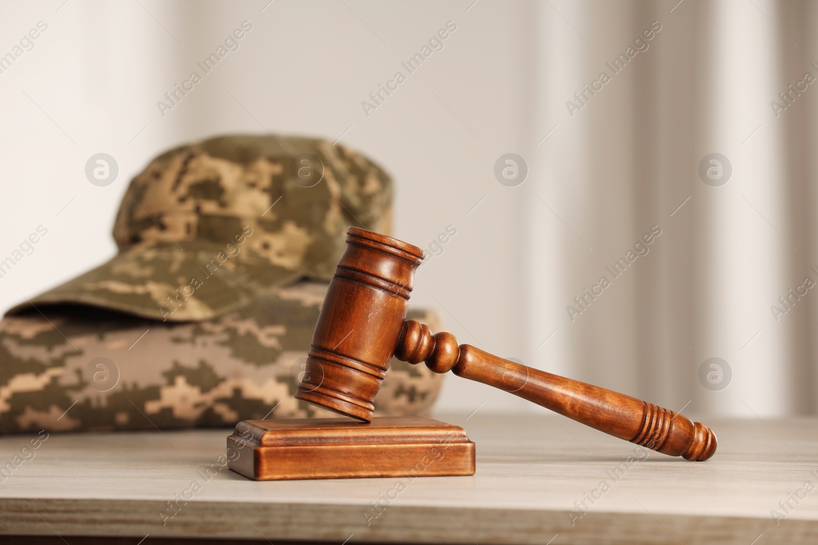Photo of Law concept. Gavel and military uniform on wooden table