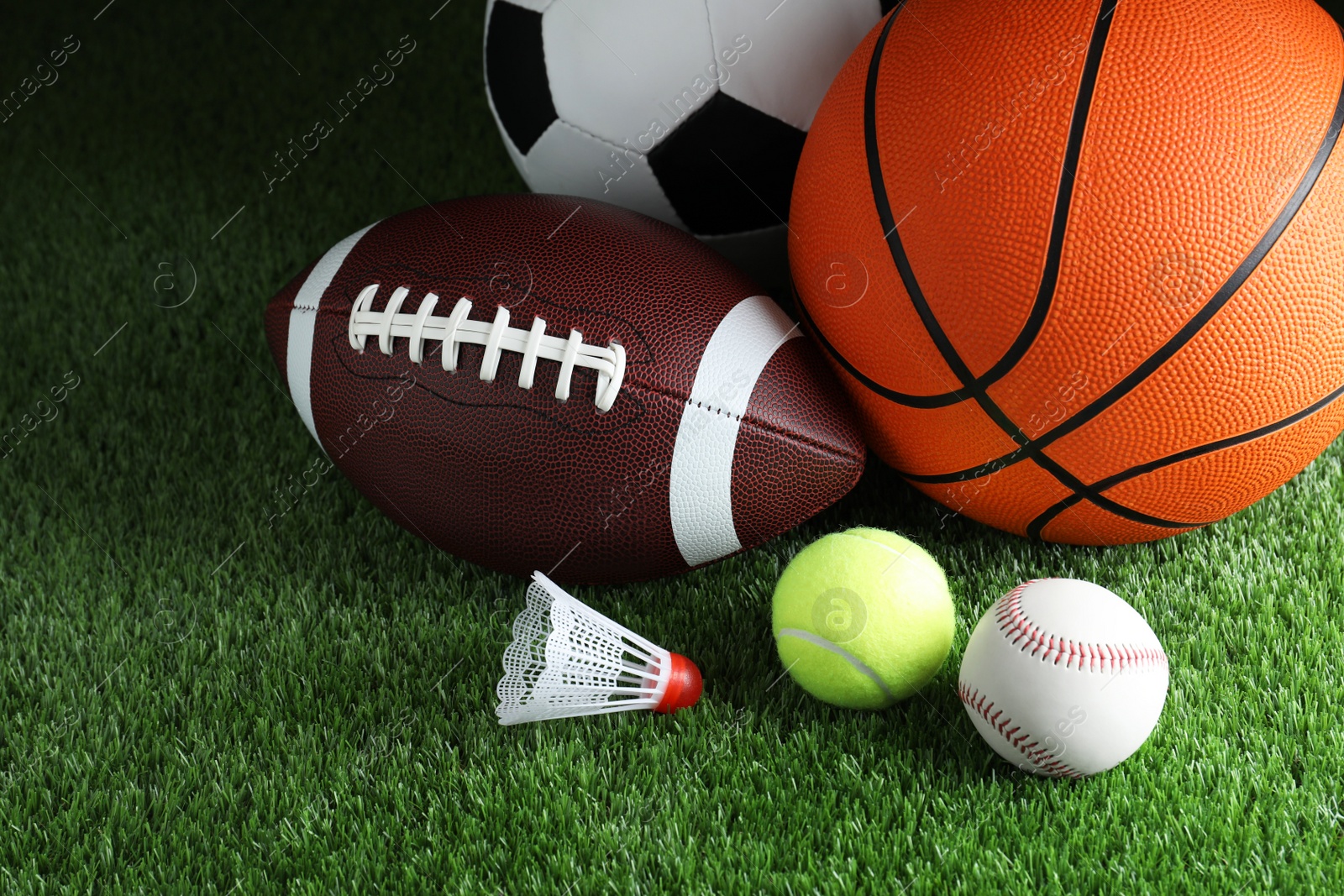 Photo of Set of different sport balls and shuttlecock on green grass