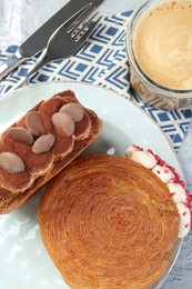 Photo of Round croissants served with coffee on table, flat lay. Tasty puff pastry