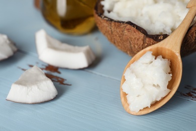 Photo of Spoon with coconut oil on table. Healthy cooking