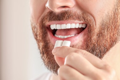 Man with chewing gums on blurred background, closeup