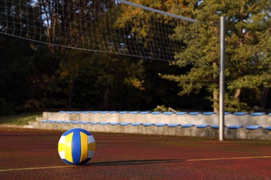 Photo of View of colorful ball on volleyball court outdoors