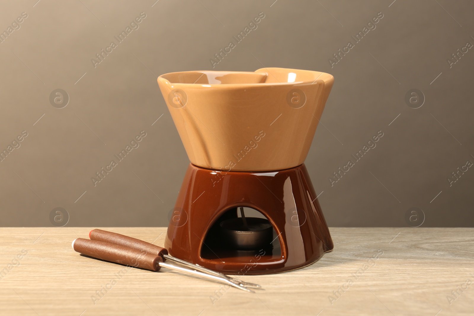 Photo of Fondue set on wooden table. Kitchen equipment