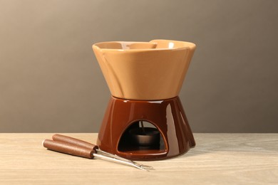 Fondue set on wooden table. Kitchen equipment