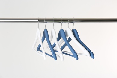 Metal rack with clothes hangers on white background