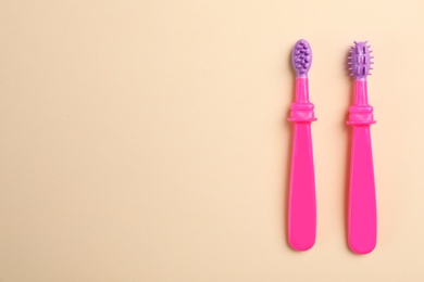 Manual toothbrushes for children on color background, top view with space for text