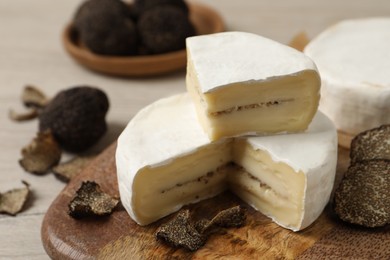 Photo of Delicious cheese with fresh truffles on wooden table, closeup