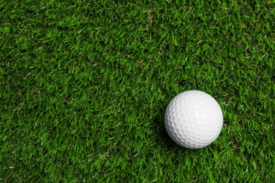 Photo of Golf ball on green artificial grass, top view with space for text