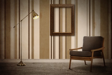 Image of Armchair, floor lamp near wall with wooden frame and patterned wallpaper. Stylish room interior