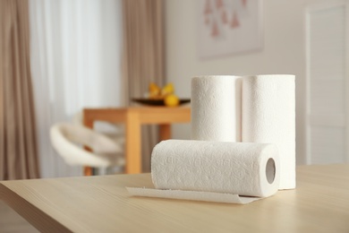 Photo of Rolls of paper towels on table indoors. Space for text