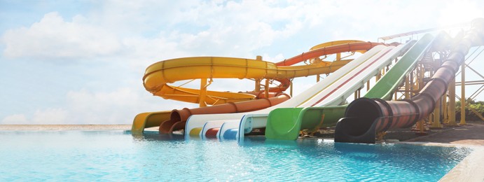 Image of Beautiful view of water park with colorful slides and swimming pool on sunny day. Banner design