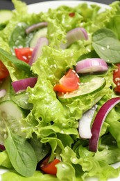 Photo of Delicious salad with cucumbers and tomatoes in white bowl, closeup