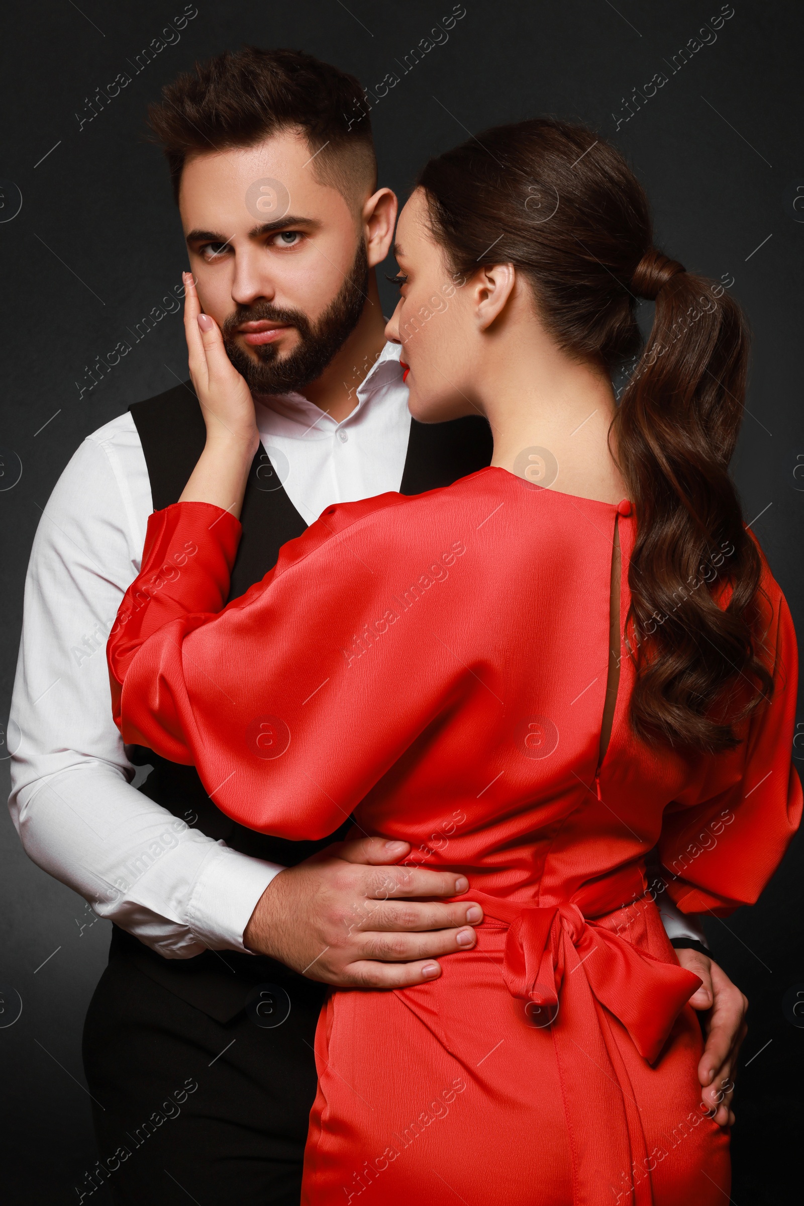 Photo of Handsome bearded man with sexy lady on dark background