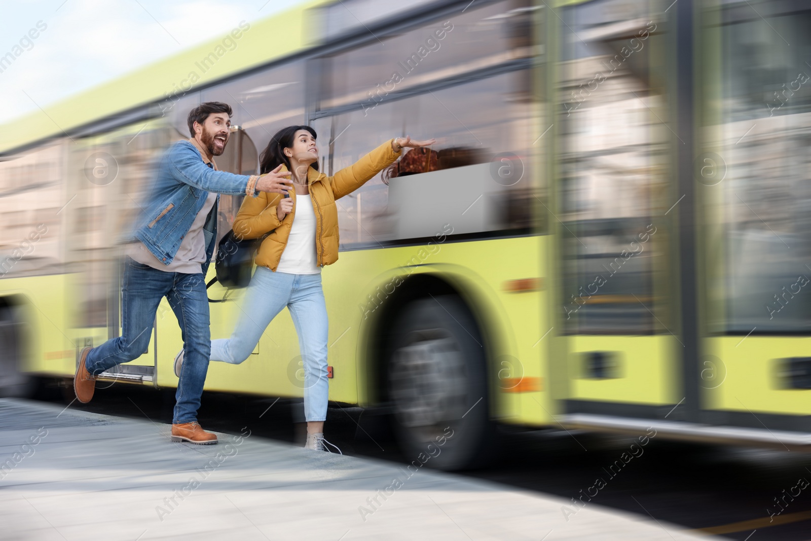 Image of Being late. Couple running after bus outdoors. Motion blur effect