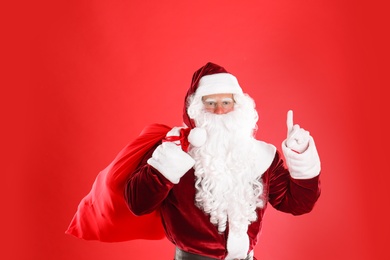 Photo of Santa Claus with sack on red background