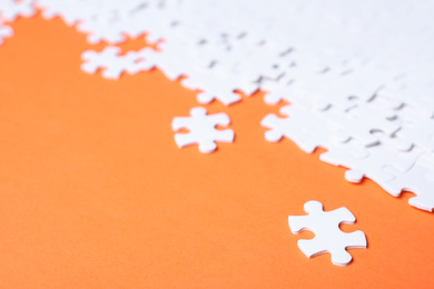 Photo of Blank white puzzle pieces on orange background