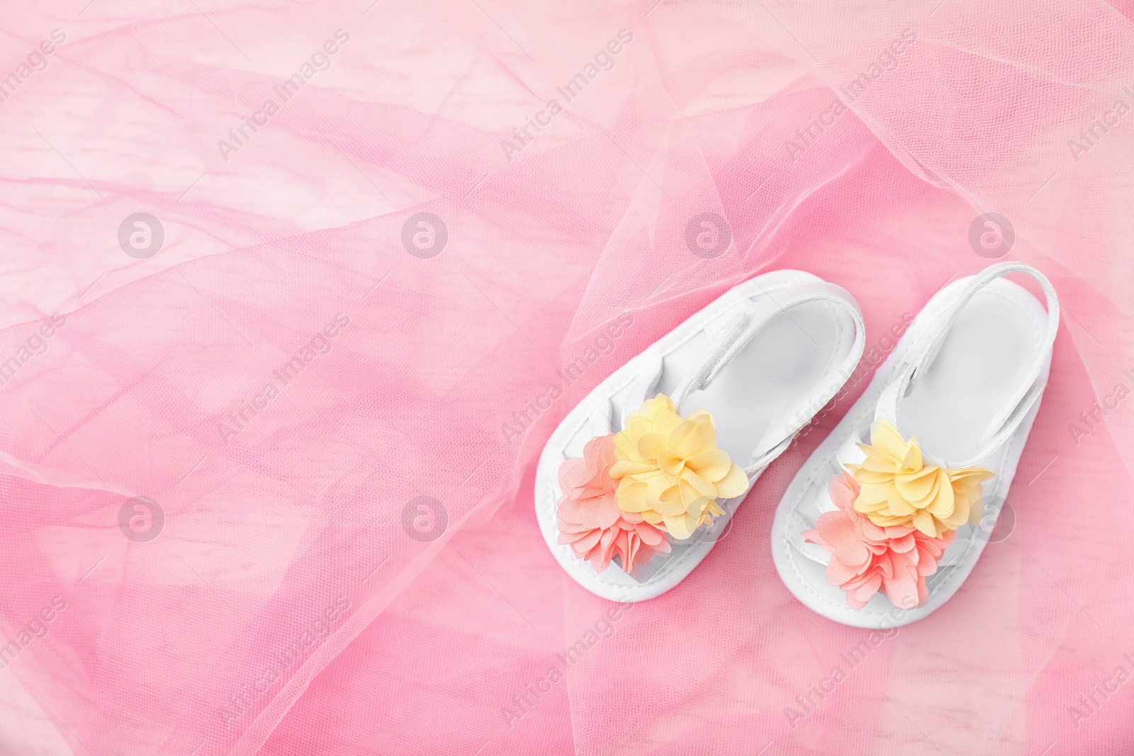 Photo of Pair of cute baby sandals on color fabric, top view