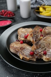 Photo of Tasty beef tongue pieces on dark table, closeup