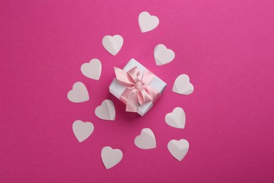 Photo of Beautiful gift box and hearts on pink background, flat lay. Valentine's day celebration