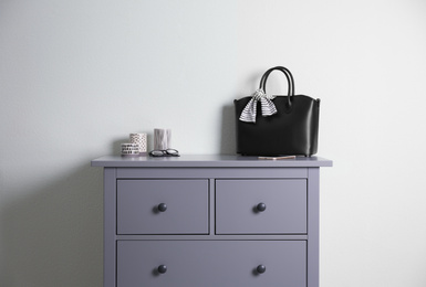 Grey chest of drawers near light wall in room